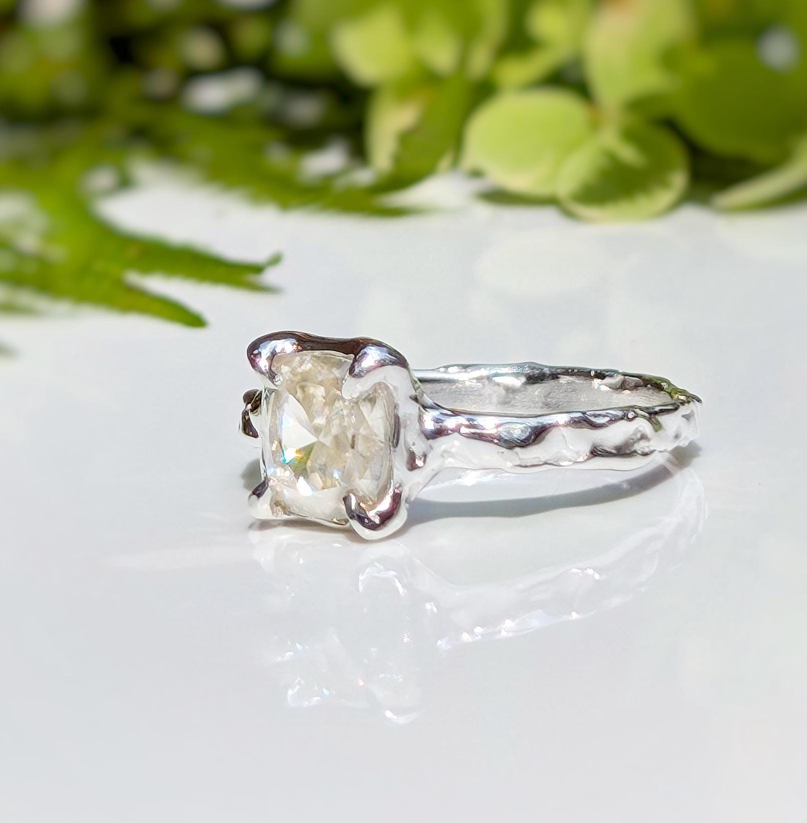 Moissanite engagement ring with cushion cut gemstone in unique textured silver setting