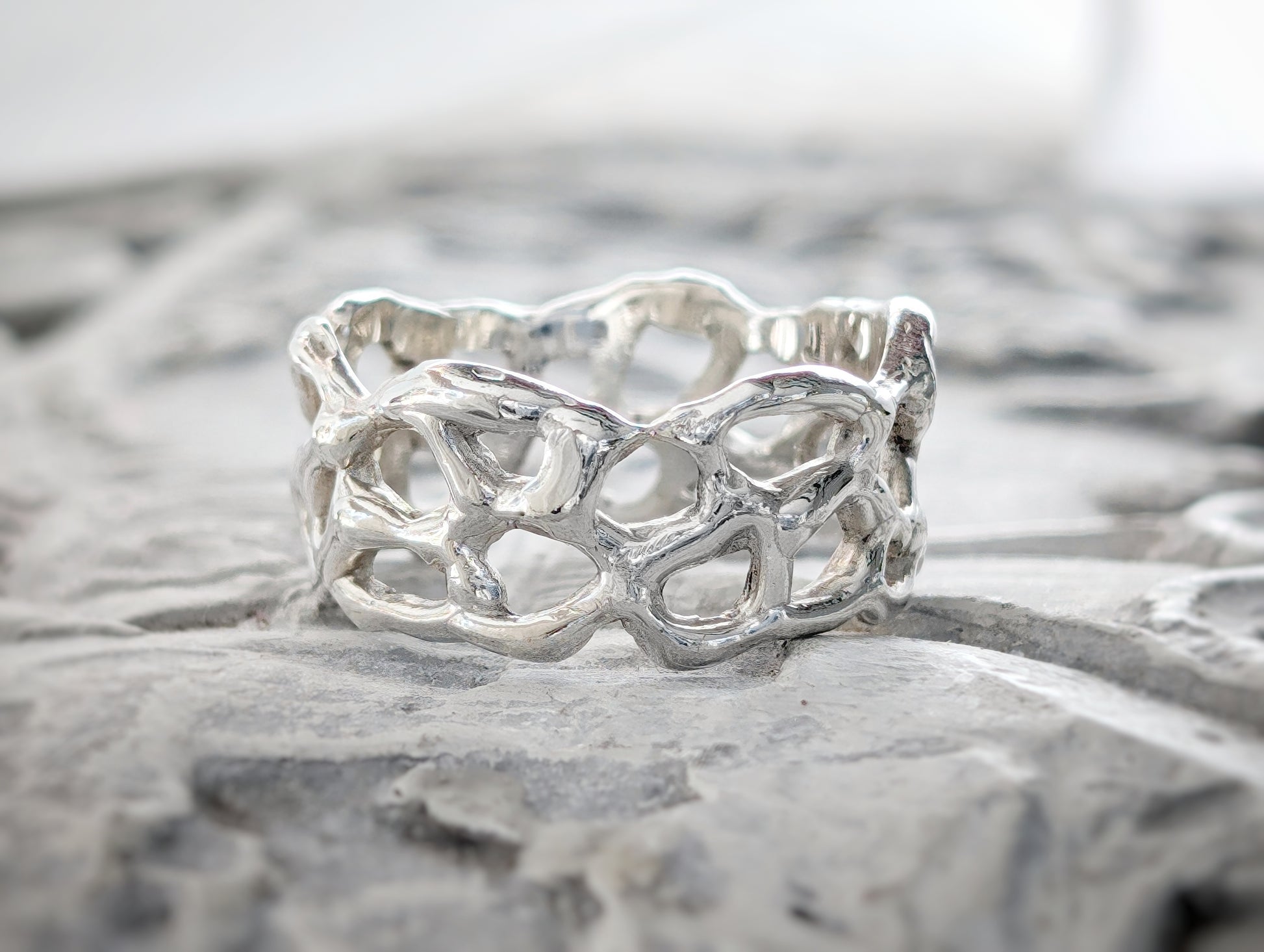 Molten Silver Honeycomb ring with an abstract, organic design, showcasing its unique hand-carved texture in solid silver.