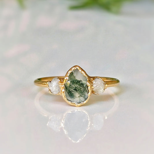Moss Agate and raw diamond engagement ring on a gold band with a pear-shaped moss agate centerpiece.