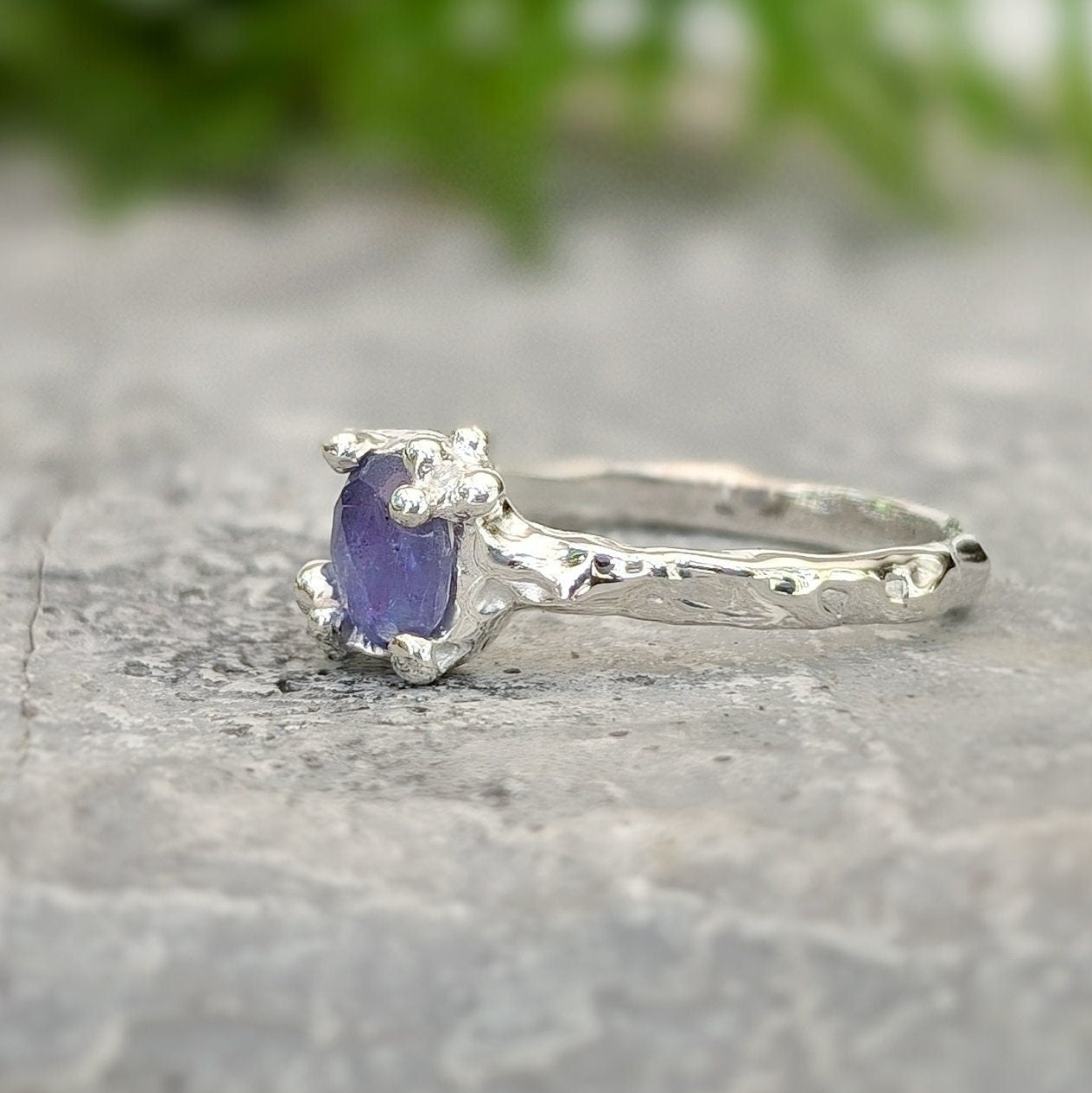 Dainty silver Tanzanite ring with organic molten band, showcasing a unique purple gemstone.