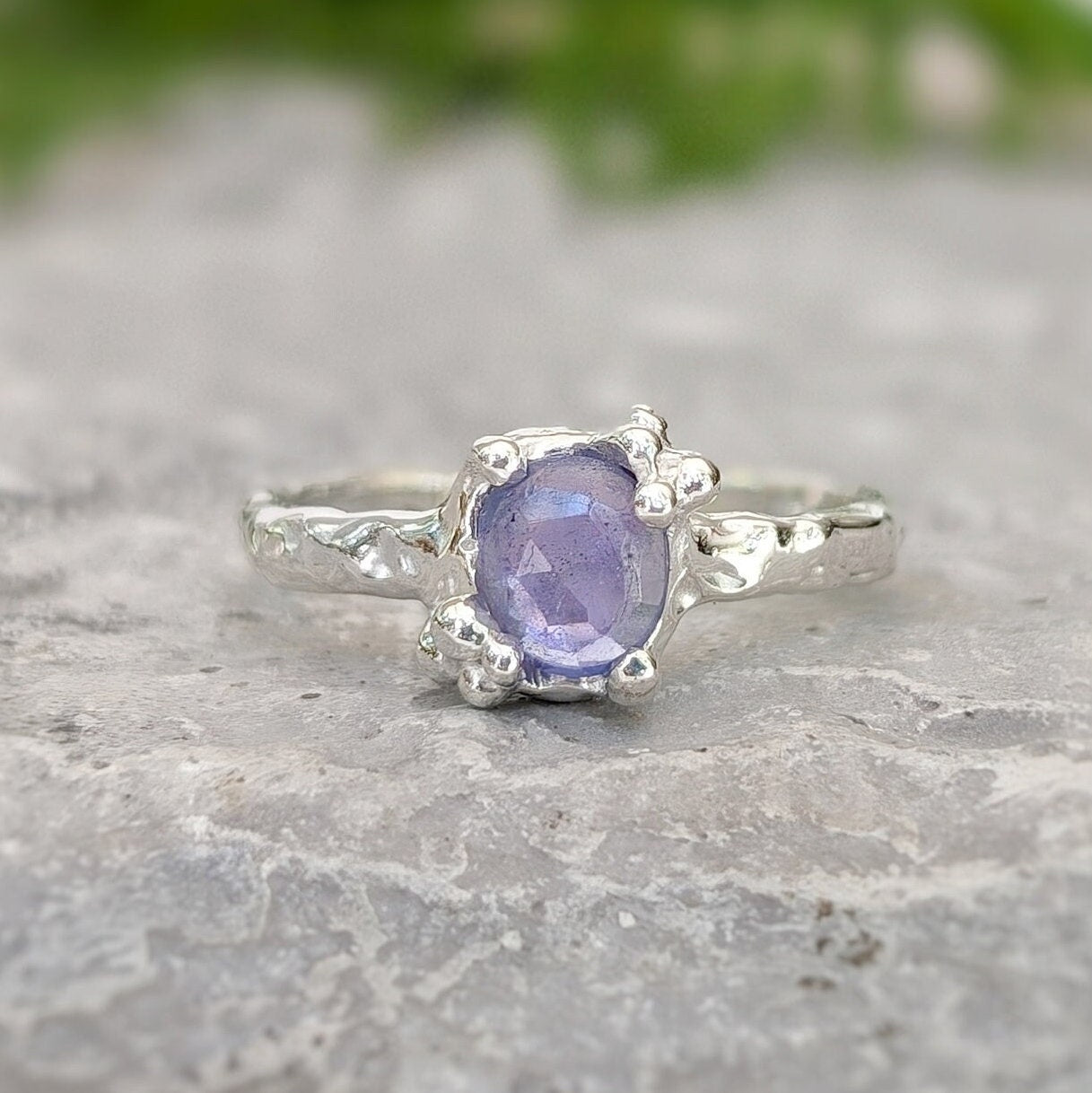 Dainty natural Tanzanite ring with a textured sterling silver band, showcasing a unique purple gemstone.