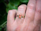 Hand wearing a radiant cut Orange Sapphire textured ring in Solid 14k Gold, showcasing a unique engagement ring design.