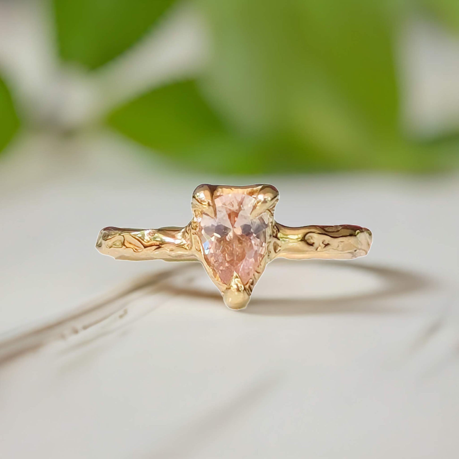 Handcrafted peach Morganite ring in solid 14k gold with an organically textured band.