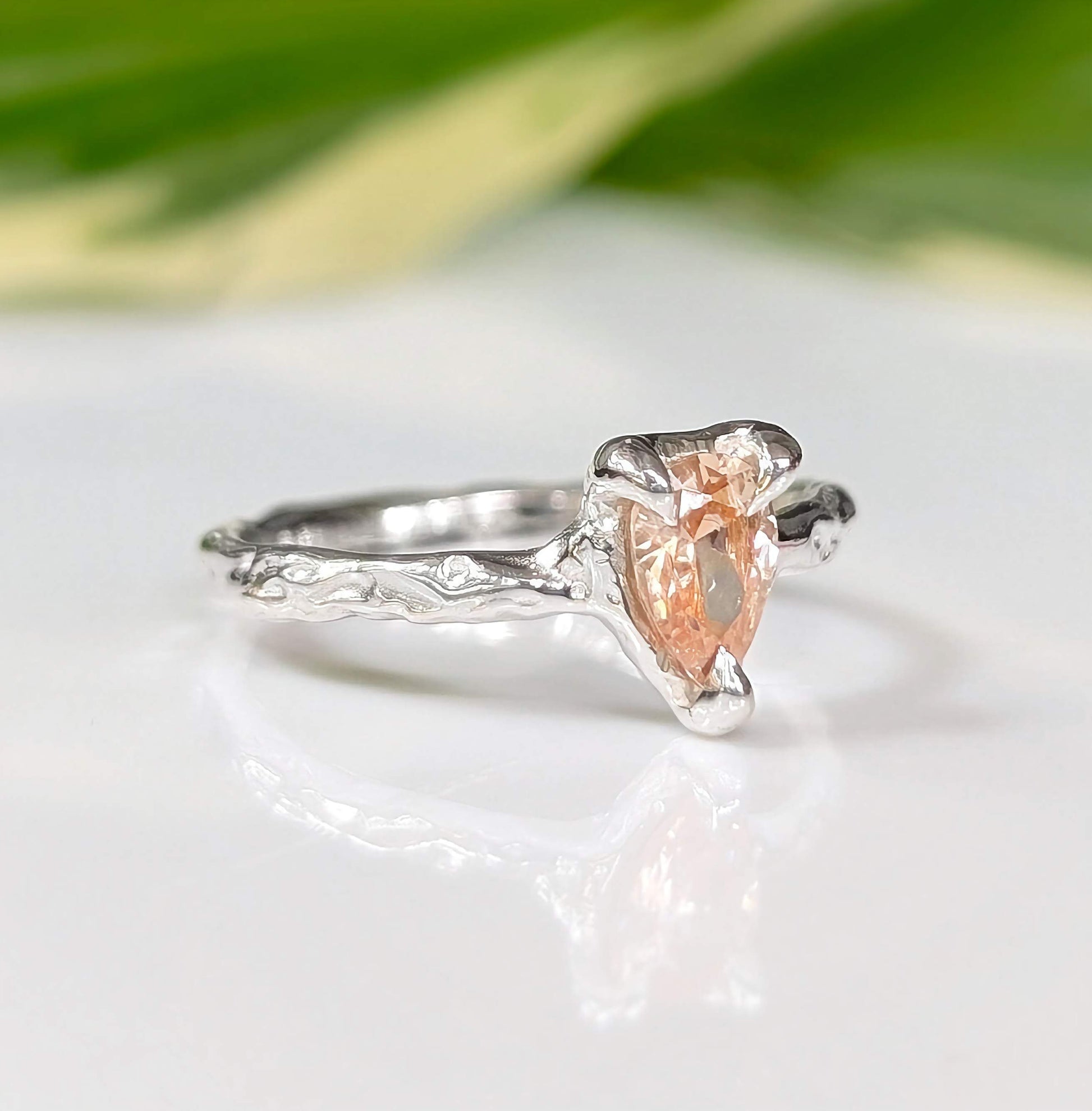 Handcrafted pear-shaped Peach Morganite ring in solid 14k gold with textured band, blending rustic charm and elegance.