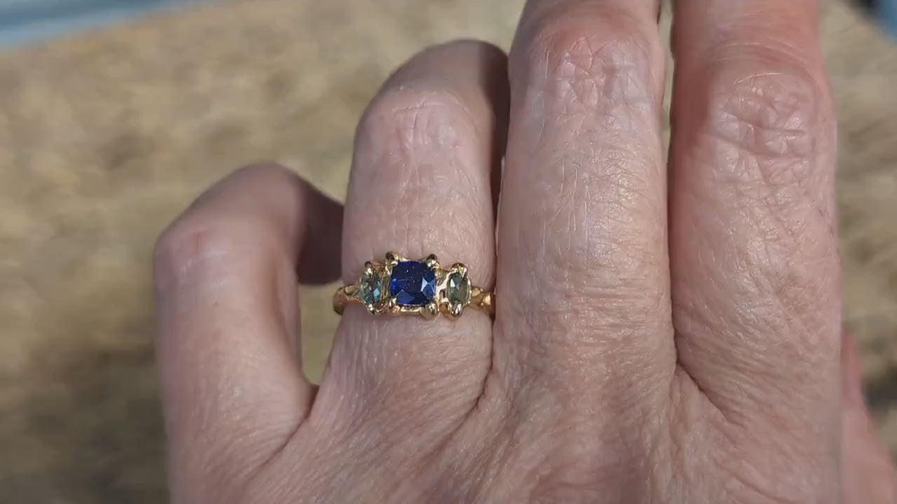 Blue Sapphire and Tourmaline engagement ring in solid 14k gold worn on hand, showcasing elegant rustic design.