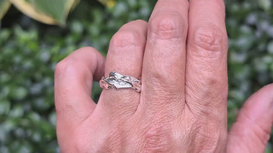 Hand wearing a sterling silver molten textured ring, showcasing unique design and fluid metal-like appearance.