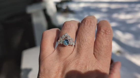 Raw Montana Sapphire and diamond bridal ring set on hand, featuring teal blue sapphire and conflict-free diamonds.