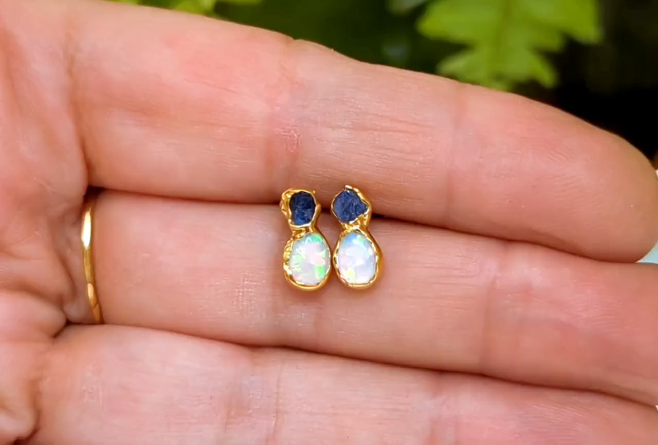 Dainty raw Sapphire and Opal stud earrings in gold setting, showcased in a hand, perfect for bridal or everyday wear.