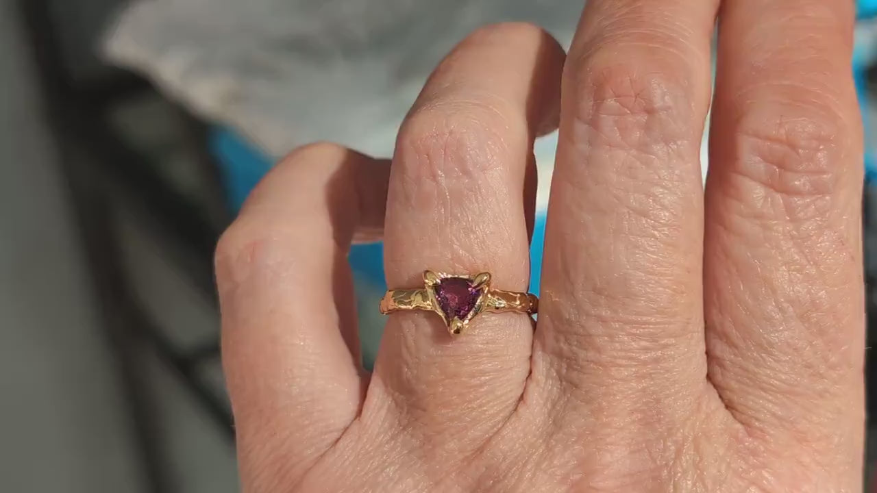 Rubellite Tourmaline trilliant ring in solid 14k gold on a hand, showcasing a unique handcrafted design.