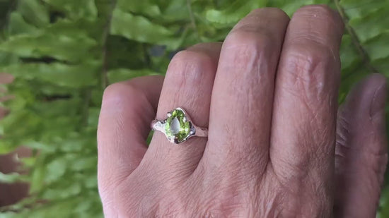 Handcrafted peridot ring in solid 14k gold, showcasing a unique organic textured band, worn on a hand.