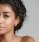 Model showcasing dainty raw Aquamarine and Opal stud earrings against a neutral background.