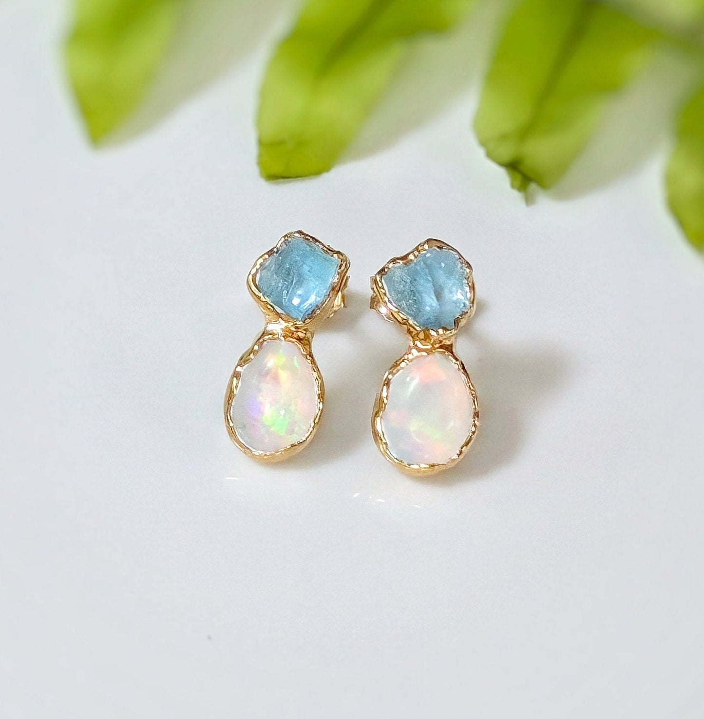 Dainty raw aquamarine and opal stud earrings with gold settings, perfect for bridal or everyday wear.