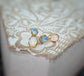 Dainty raw Aquamarine and Opal stud earrings with gold settings on a rustic background.