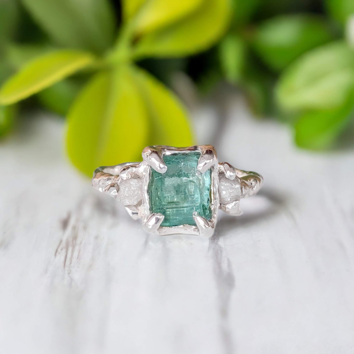 Raw Emerald and diamond engagement ring in sterling silver, featuring a mint green stone and nature-inspired design.