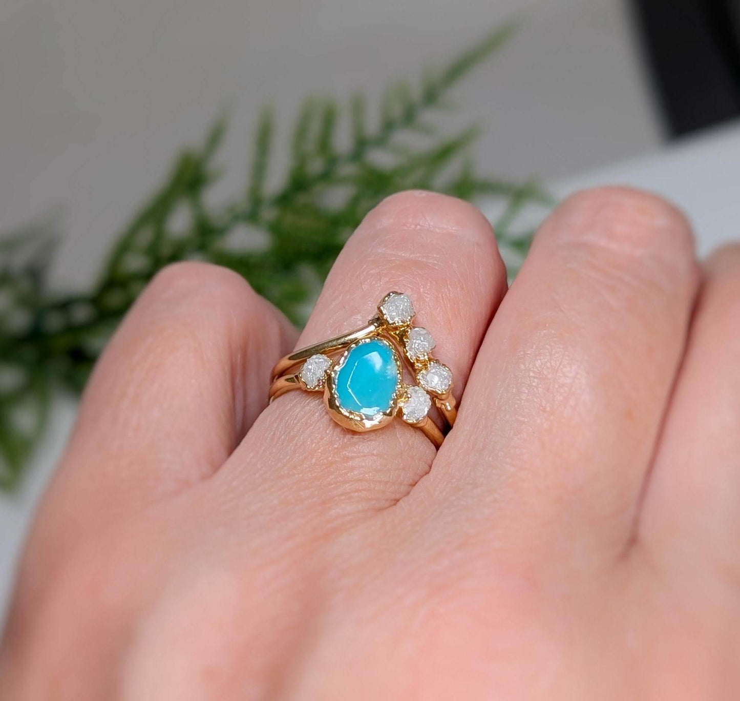 Elegant raw Peruvian Opal and diamond engagement ring set on a hand, showcasing its unique aqua-blue hue and sparkling details.