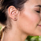 Dainty raw pink Spinel stud earrings showcased on model's ear, perfect for everyday elegance or bridal wear.