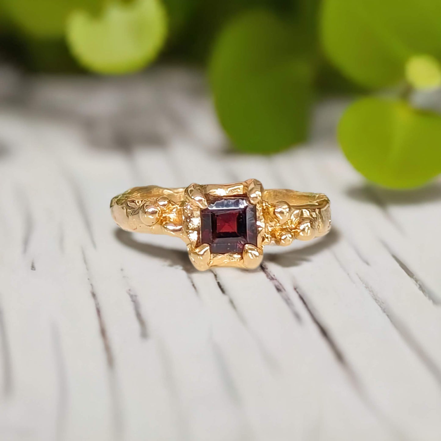 Red Garnet engagement ring in solid 14k gold with a textured band and square cut gemstone, perfect for love.