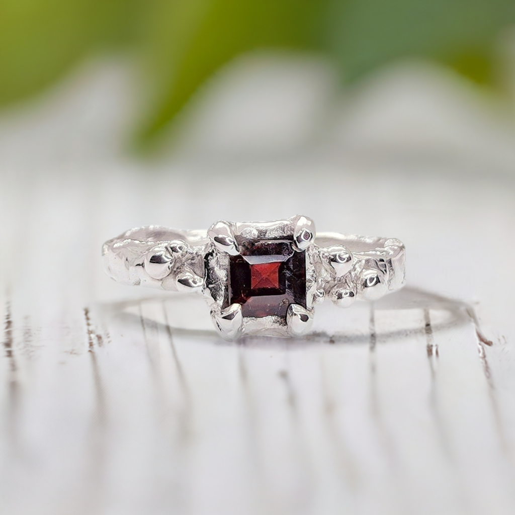 Red Garnet engagement ring in solid sterling silver with organic textured band, showcasing a square crystal.