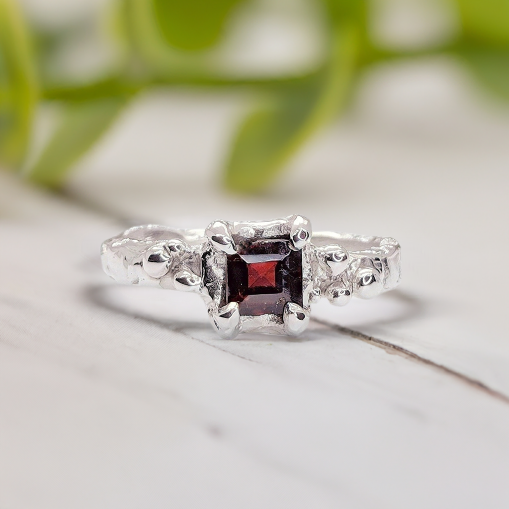 Red Garnet engagement ring in solid sterling silver with an organic textured band, featuring a square cut gemstone.