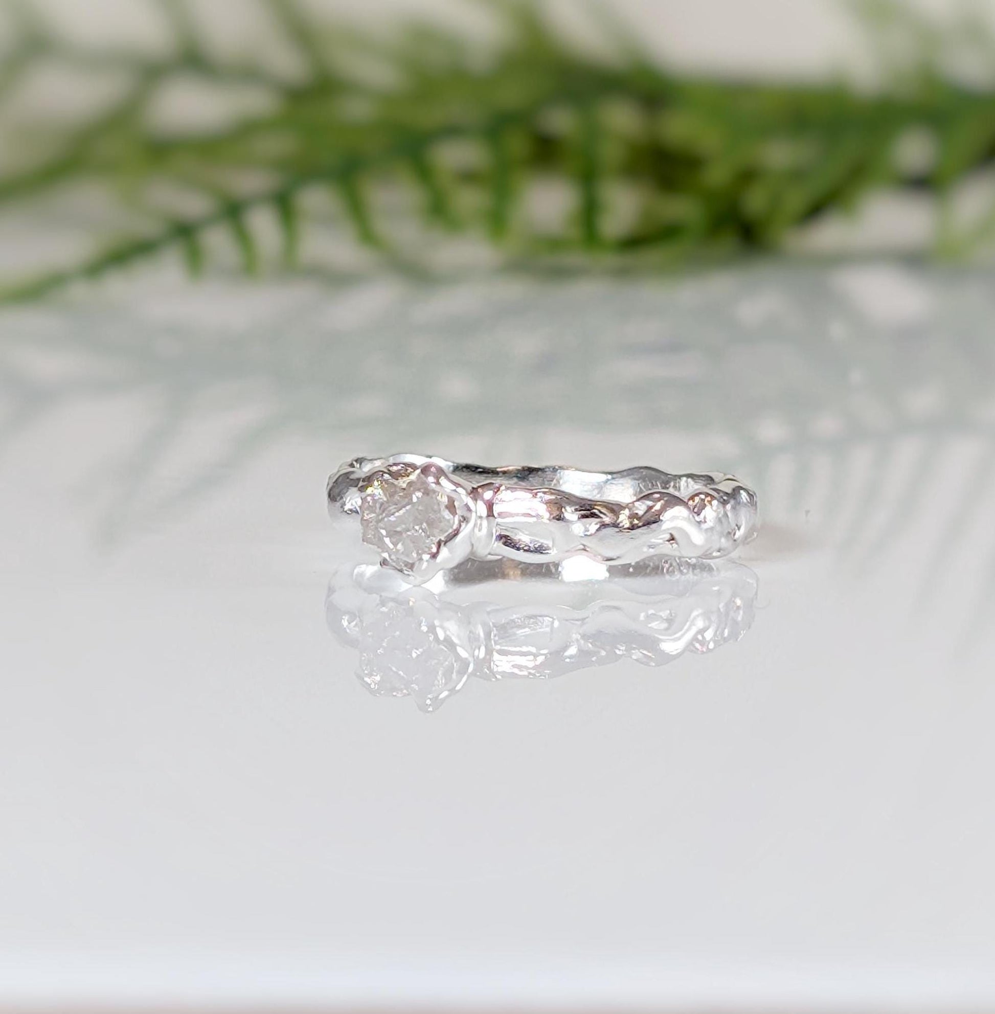 Unique raw diamond engagement ring set in recycled sterling silver with a molten texture and organic elegance.