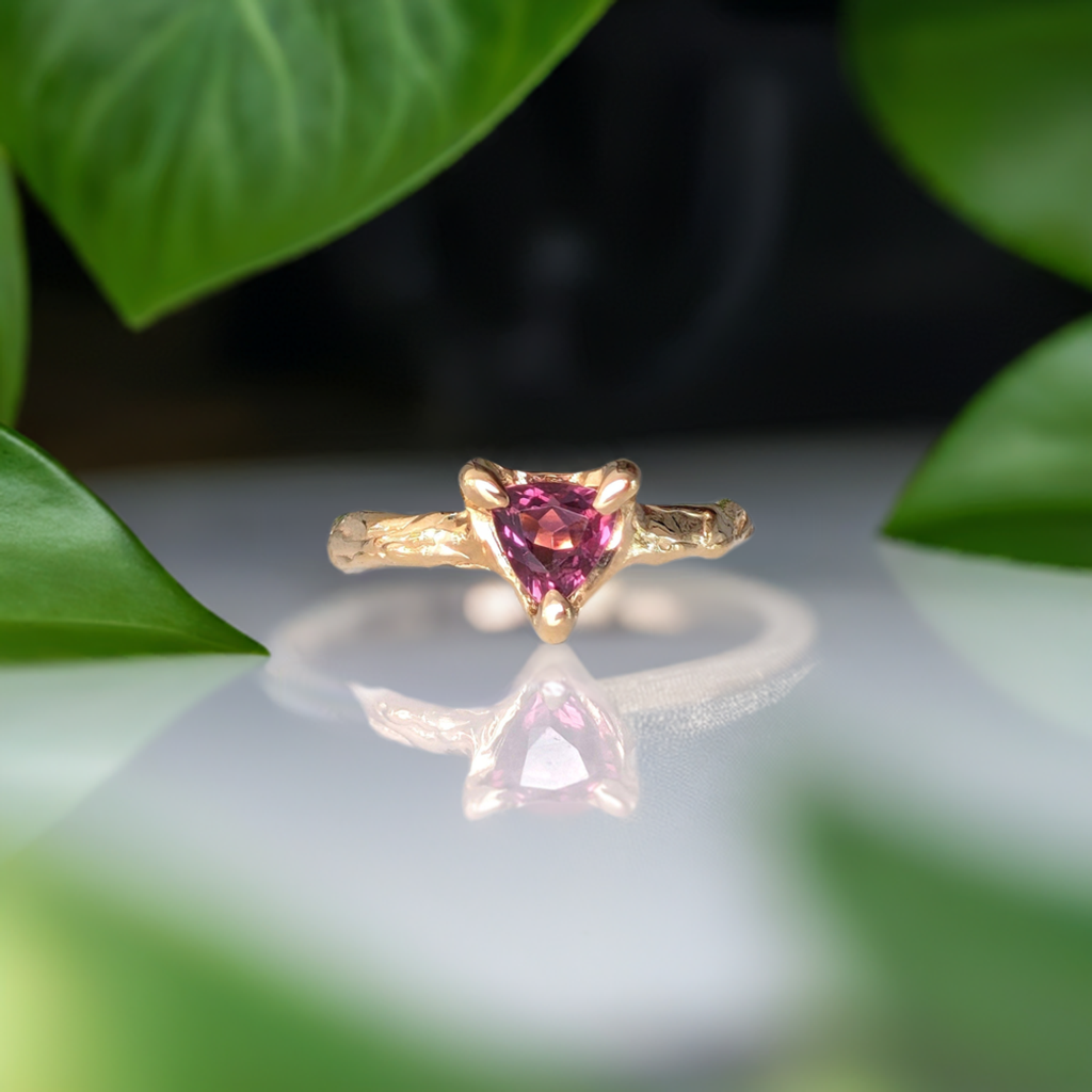 Rubellite Tourmaline engagement ring in solid 14k gold with organic textured band, featuring a trilliant dark pink stone.