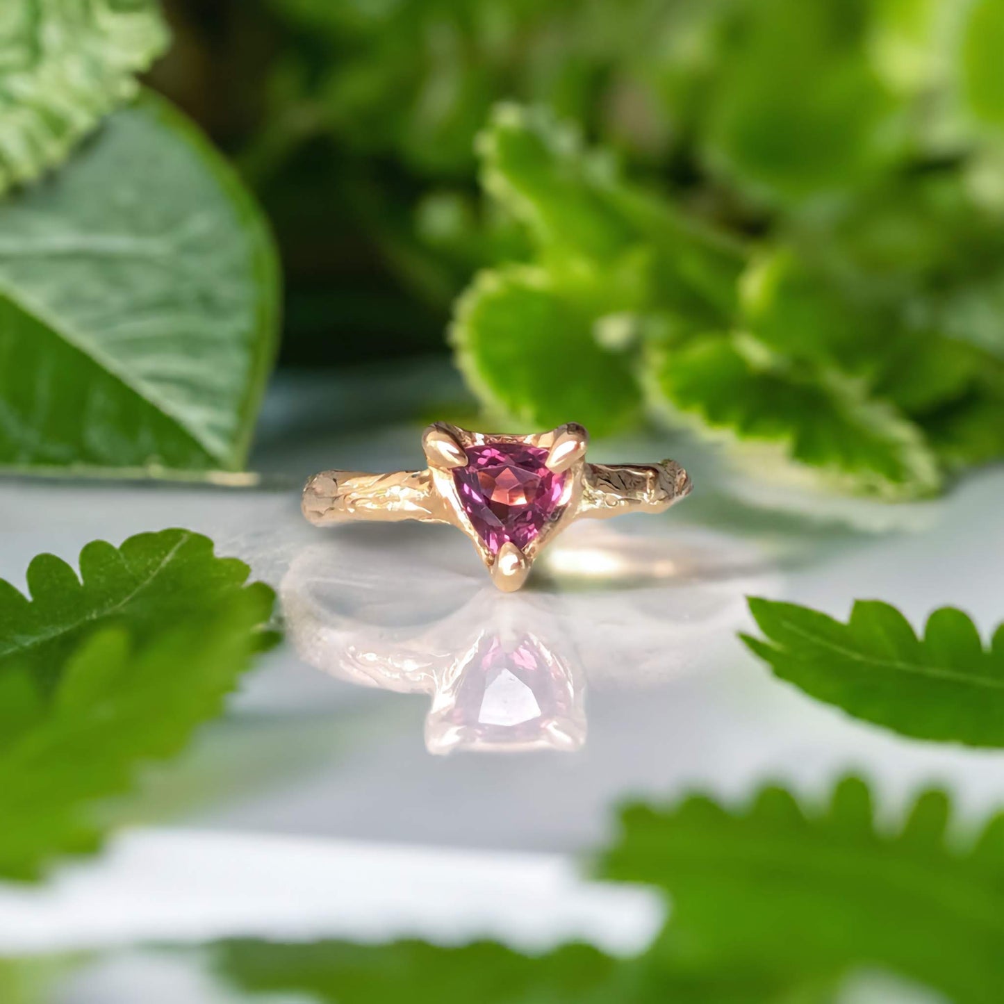 Rubellite Tourmaline engagement ring in solid 14k gold with organic textured band, featuring a trilliant-shaped gemstone.