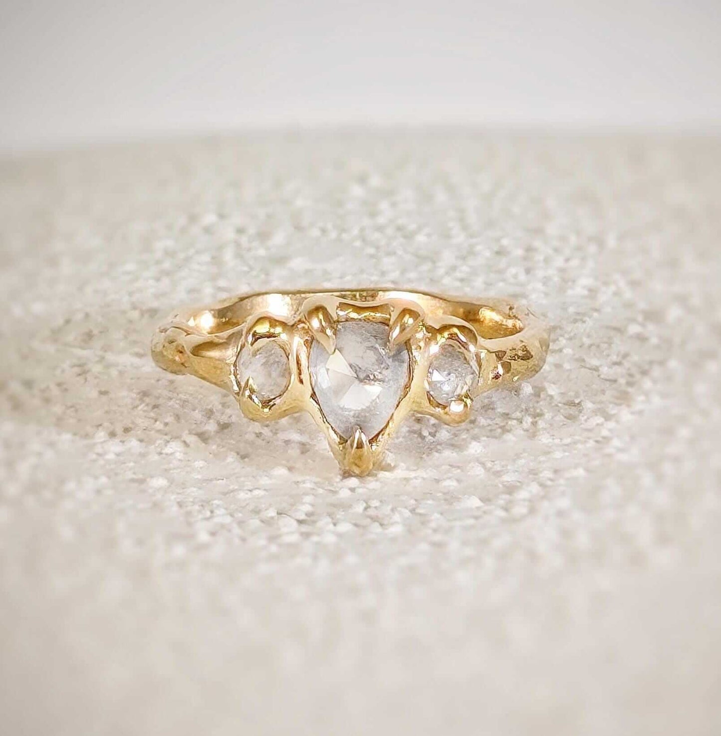 Rustic solid gold engagement ring featuring three Salt & Pepper diamonds set on a textured band.