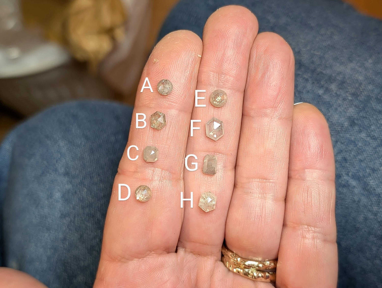 A selection of Salt & Pepper diamonds displayed on a hand, labeled A to H for easy identification.
