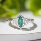 Handcrafted sterling silver engagement ring featuring a marquise cut emerald and two salt & pepper diamonds.