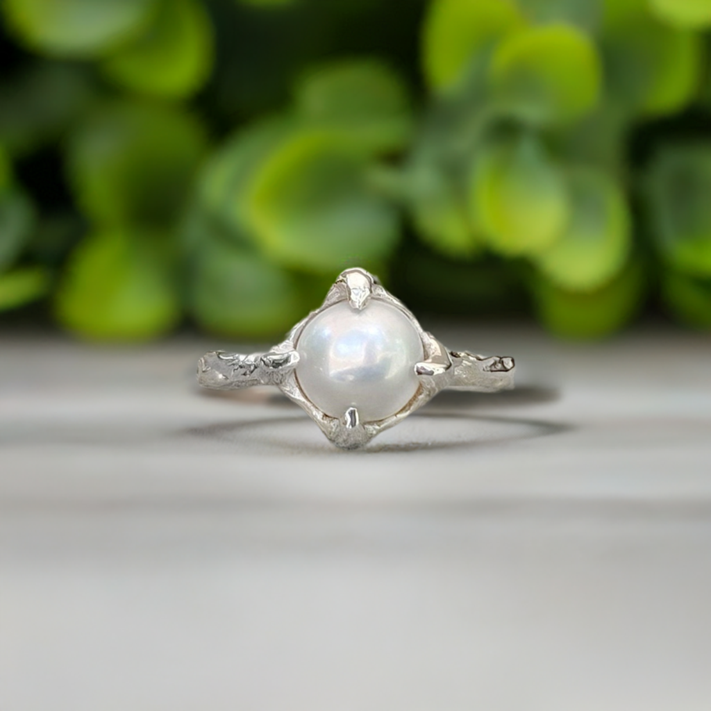 Textured sterling silver ring featuring a creamy-white Freshwater Keshi pearl, with a unique organic design.