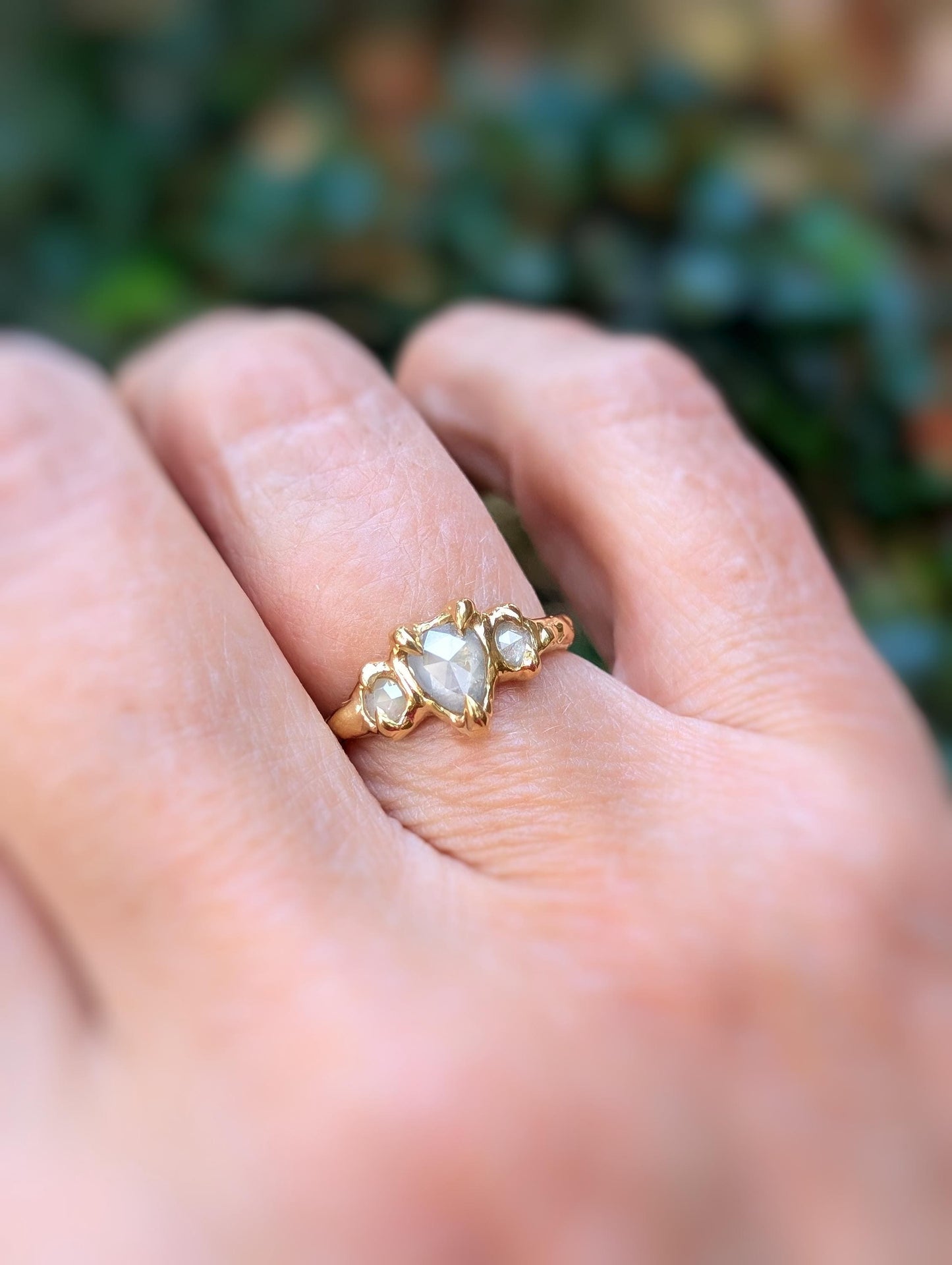 Rustic engagement ring with Salt & Pepper diamonds on gold band, worn on hand.