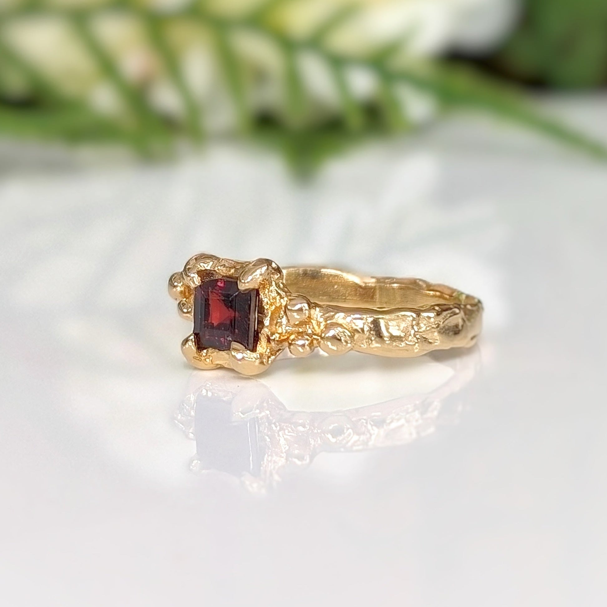 Red garnet engagement ring in solid sterling silver with an organic textured band and square cut crystal.