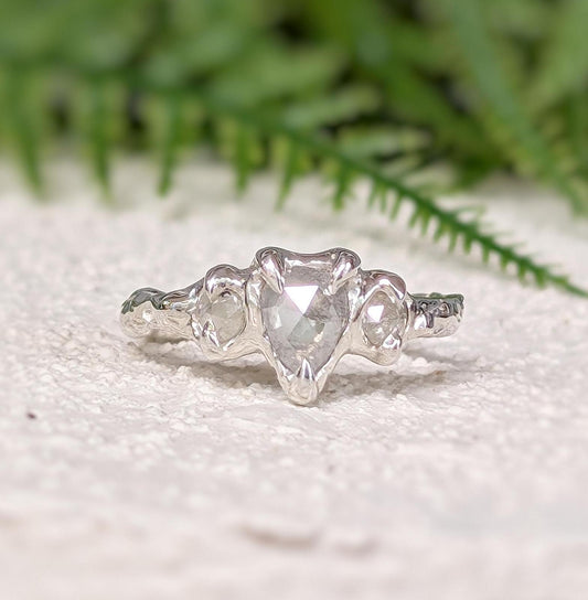Rustic sterling silver engagement ring featuring a unique salt and pepper diamond, set on a textured band.