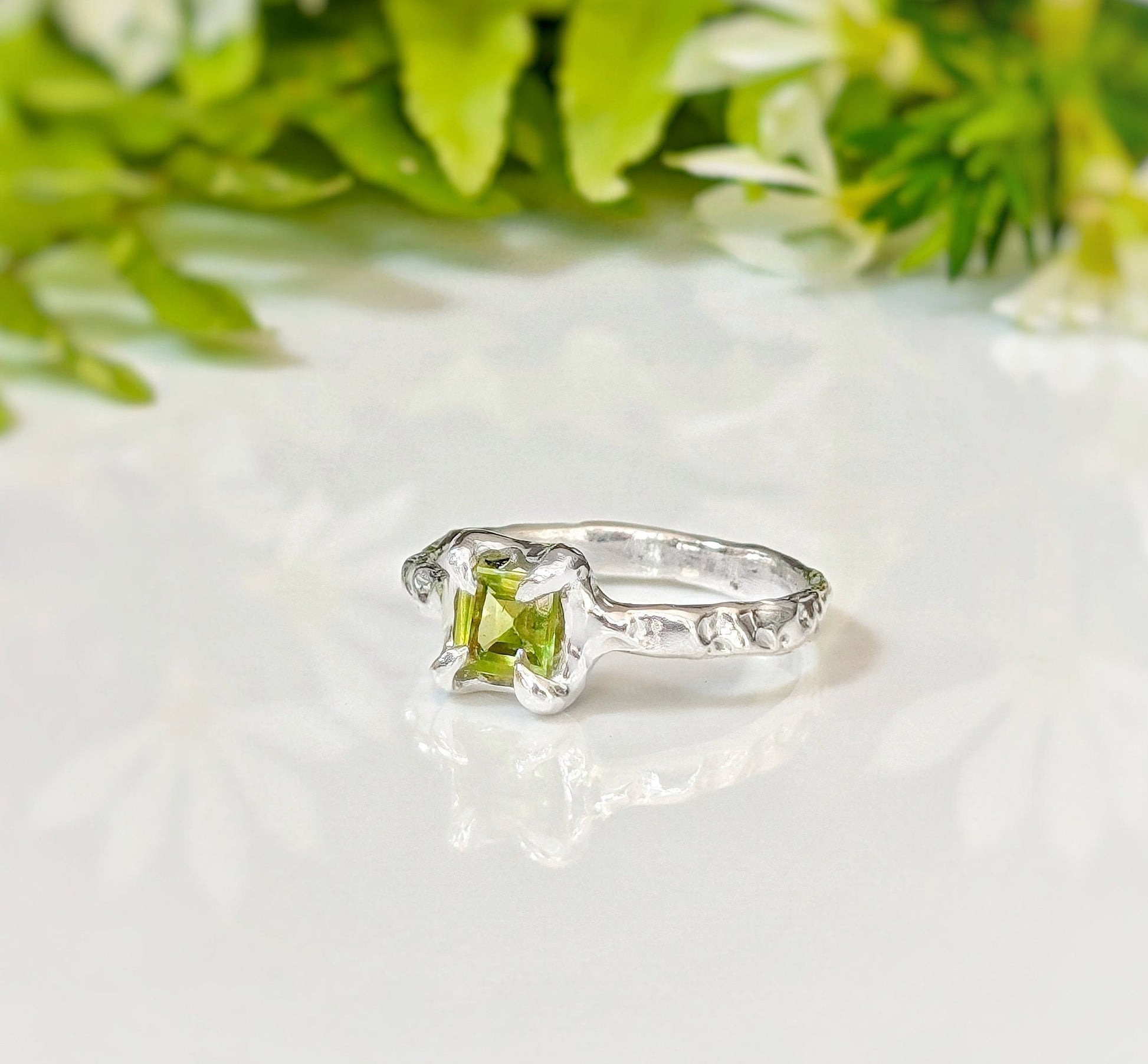 Handcrafted solid silver peridot ring with an organic textured band, featuring a princess-cut peridot gemstone.