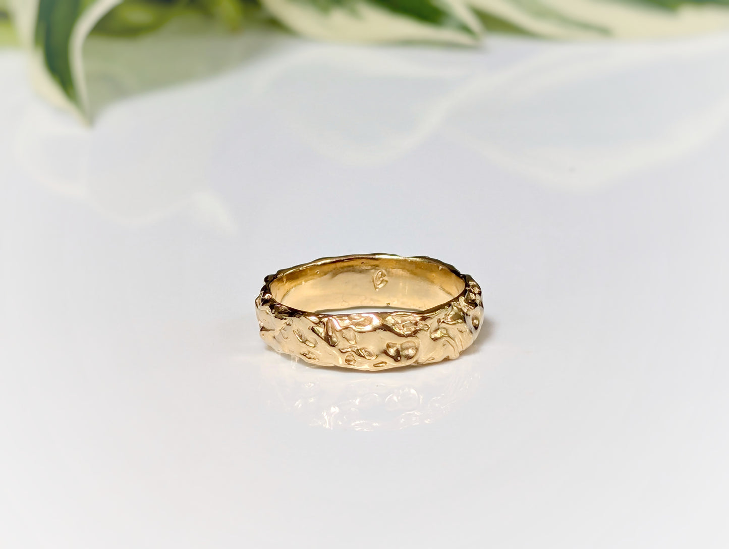 Handcrafted molten gold textured wedding ring with rustic organic design, perfect for celebrating timeless love.