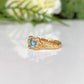 Handcrafted blue topaz engagement ring in organic textured gold, featuring a vibrant blue crystal.