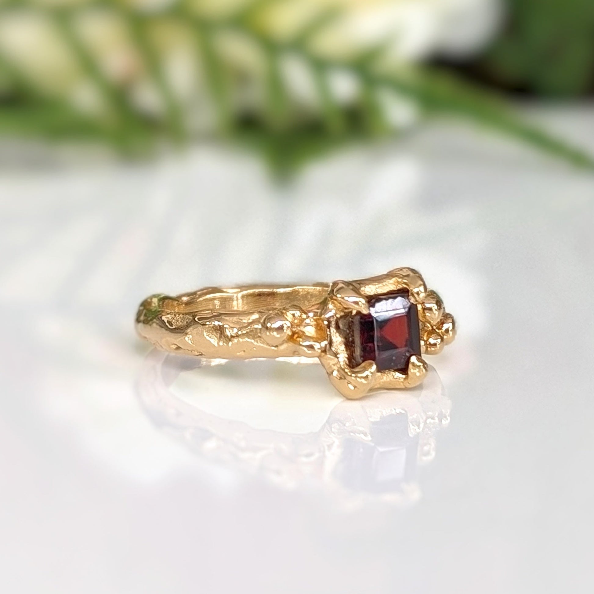 Red Garnet engagement ring in solid sterling silver, featuring a square cut stone and organic textured band.