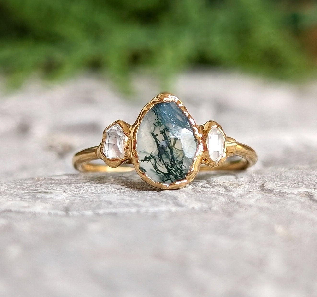 Moss Agate and Herkimer diamond engagement ring on a textured surface with nature-inspired design.