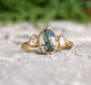 Moss Agate and Herkimer diamond engagement ring on a textured surface with nature-inspired design.