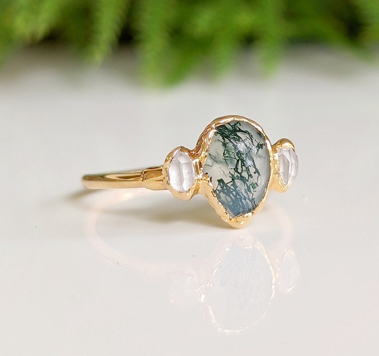 Moss Agate and Herkimer diamond engagement ring with gold band, featuring organic pear-shaped stone.