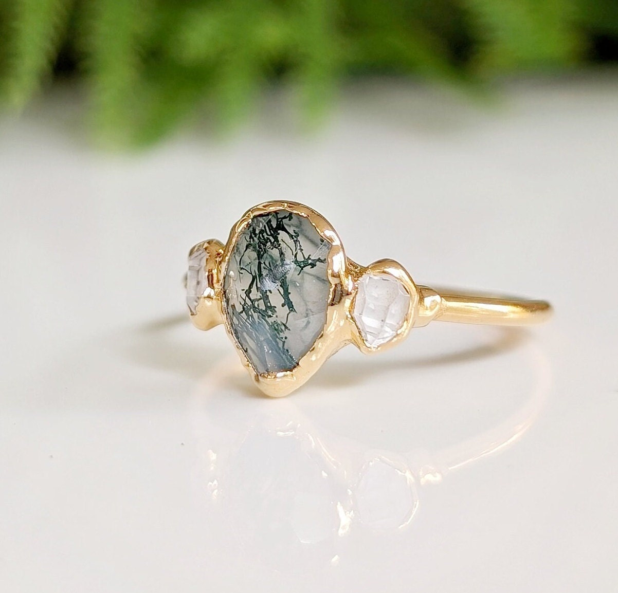 Pear-shaped Moss Agate ring with Herkimer diamonds on a 14k Gold band, showcasing natural beauty and elegance.