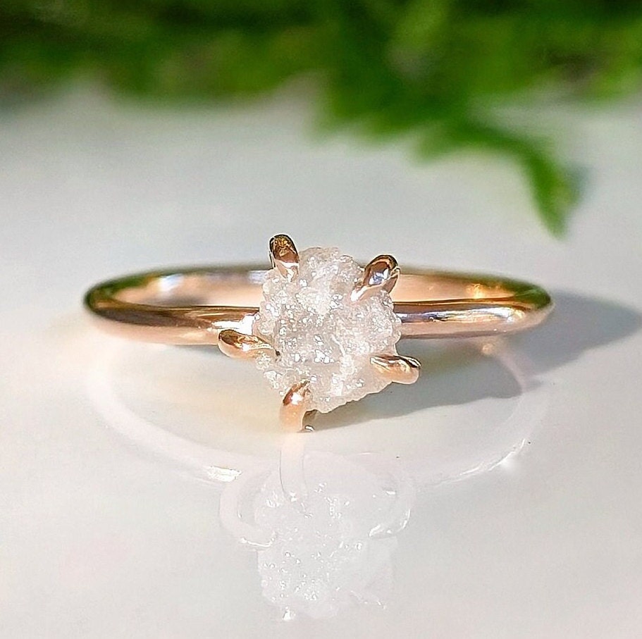 Raw diamond engagement ring with uncut diamond set in a rose gold band, symbolizing unique love and nature's beauty.