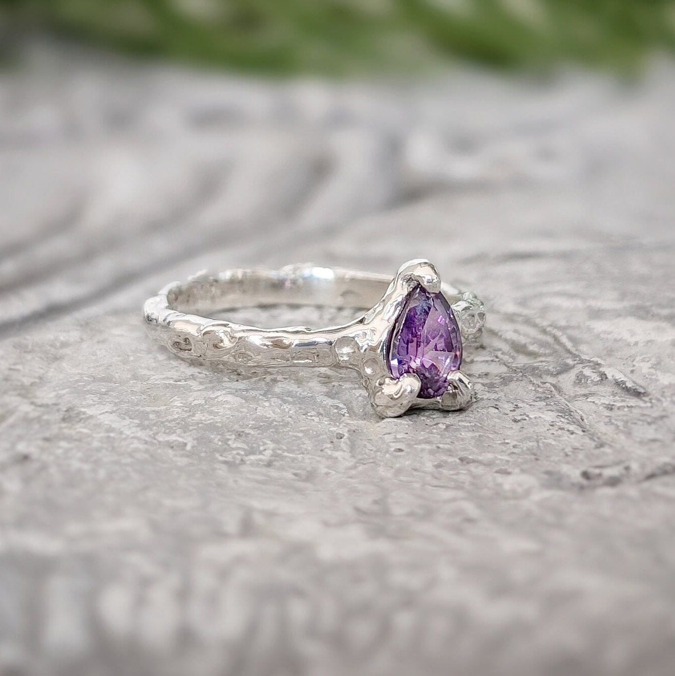 Amethyst engagement ring in solid sterling silver with pear-shaped purple crystal and textured band.