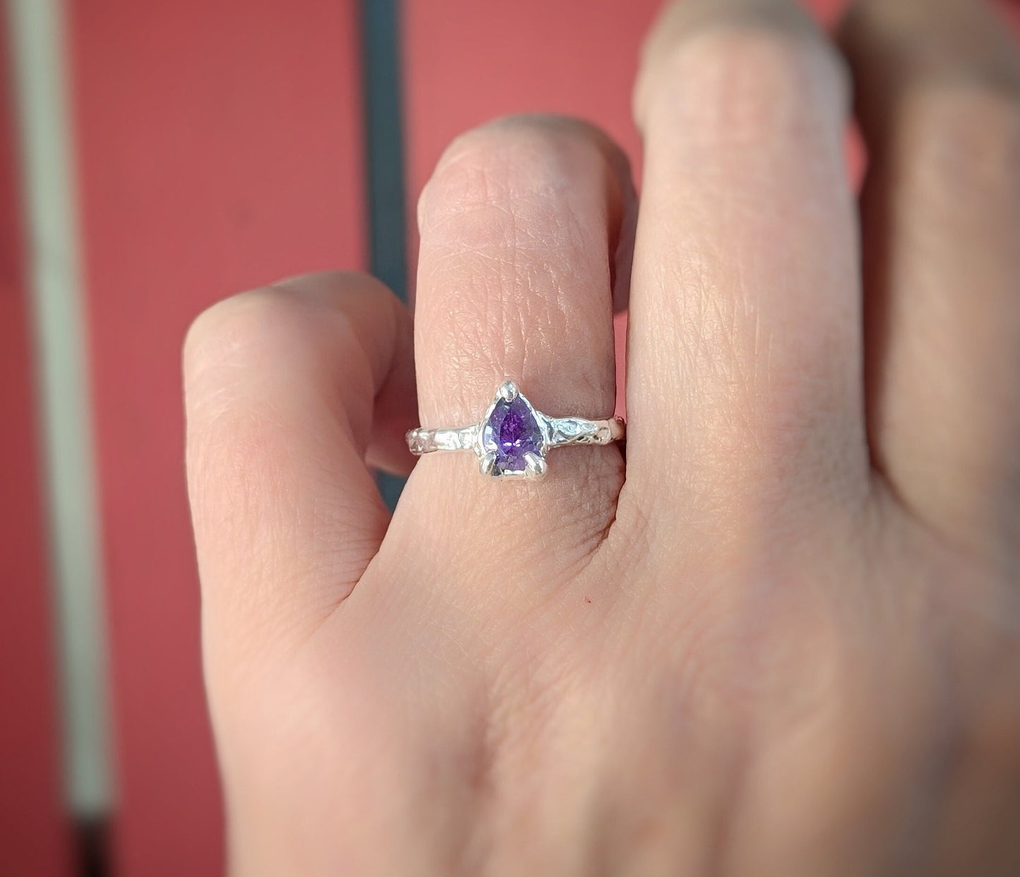 Elegant Amethyst engagement ring in Solid Sterling Silver showcased on a hand, highlighting its pear-shaped crystal and textured band.