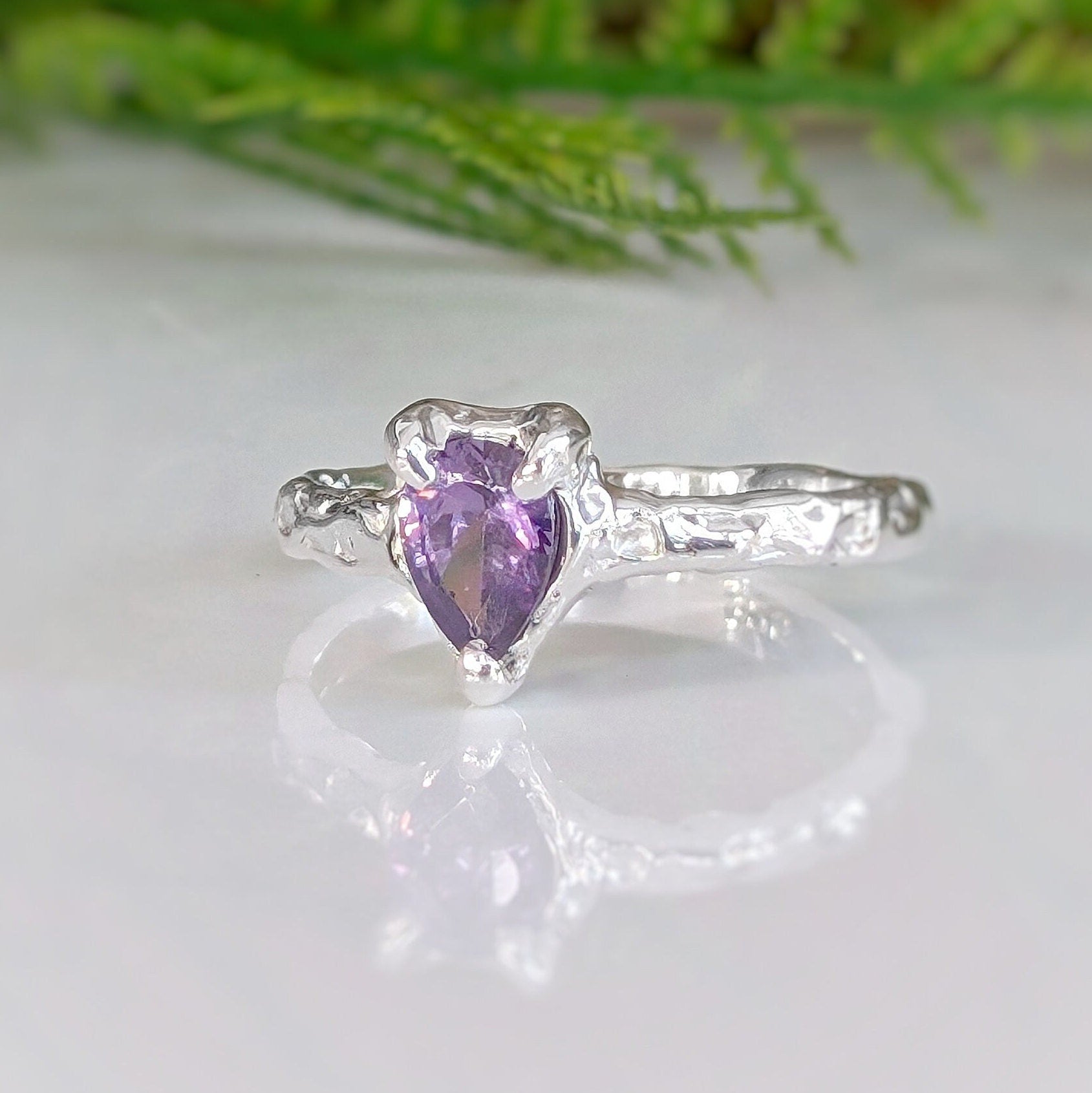 Handcrafted solid sterling silver amethyst engagement ring with organic textured band and pear-shaped purple gem.