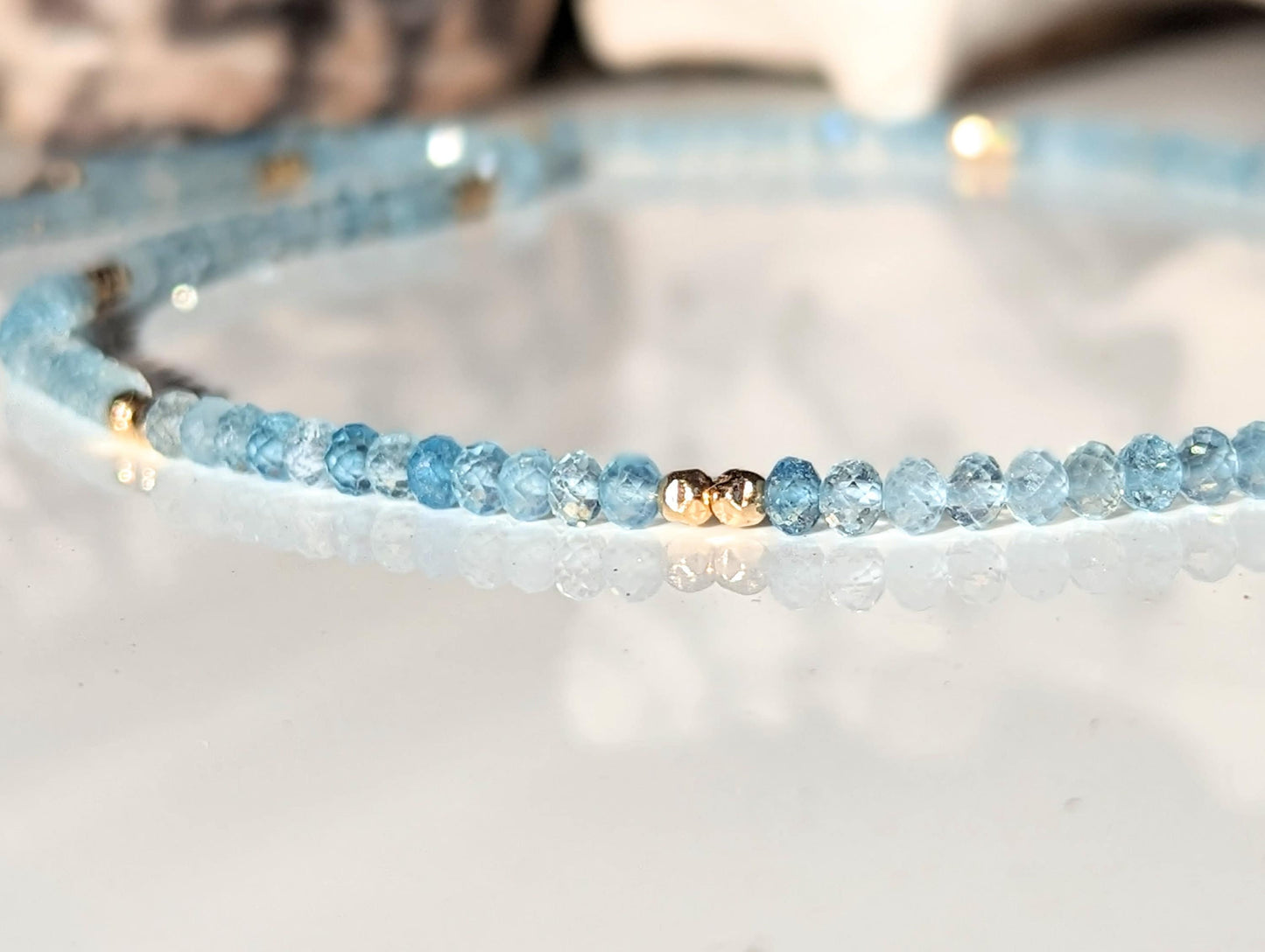 Handmade aquamarine bead necklace with natural gemstones and gold spacers, reflecting calmness and serenity.