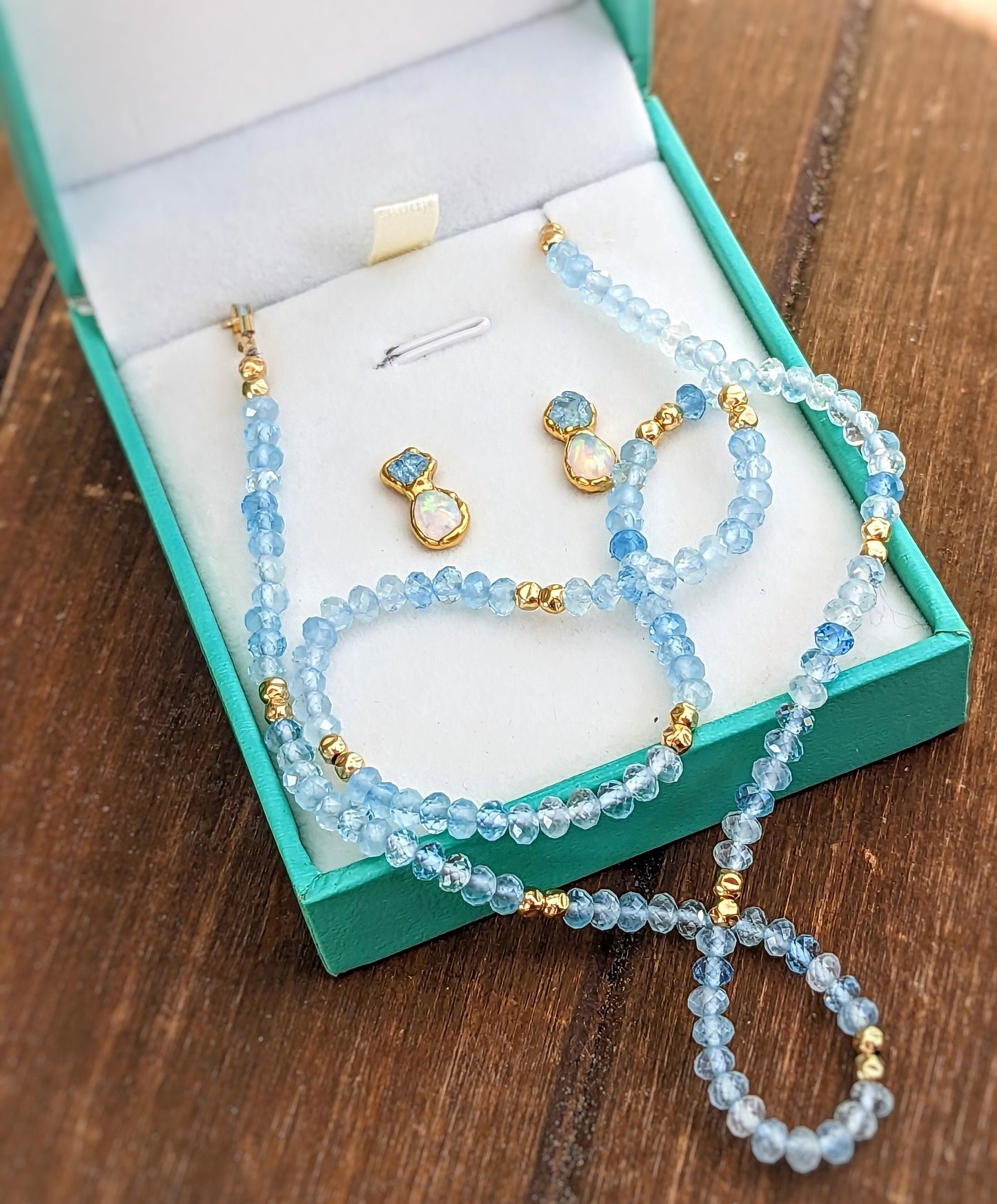 Aquamarine and Opal bridal jewelry set in a teal box, featuring bead necklace and stud earrings.