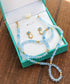 Aquamarine and Opal bridal jewelry set in a teal box, featuring bead necklace and stud earrings.