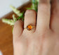 8mm natural Baltic Amber gold ring on hand, featuring a hammered 14k gold filled band and 18k gold plating.