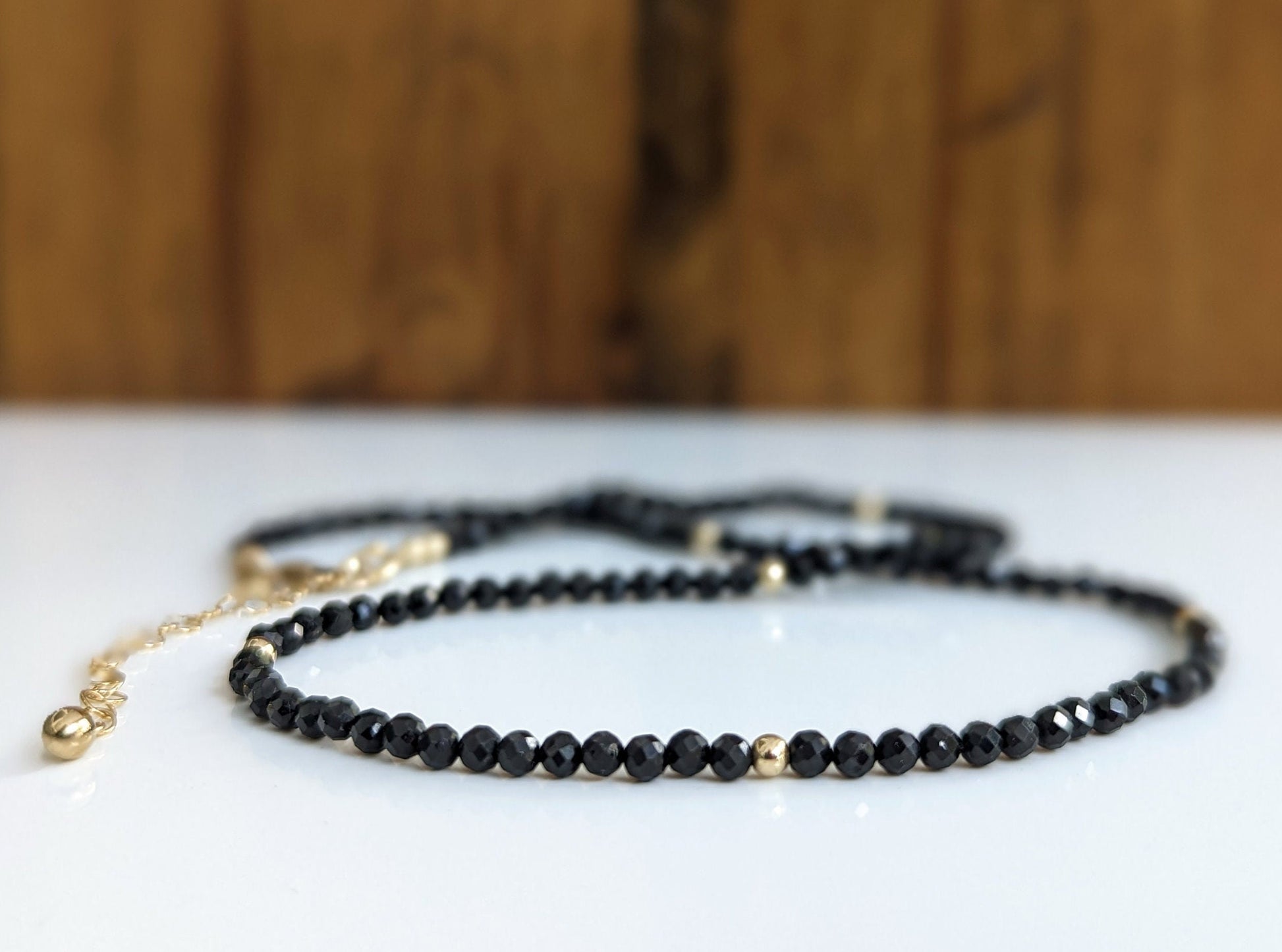 Elegant black spinel bead necklace with golden accents, perfect for any occasion or gift.